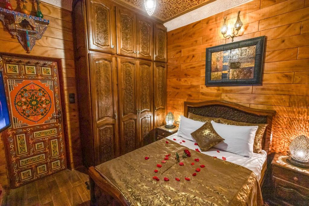 een slaapkamer met een bed met rode rozen erop bij Dar Zerbtana Apartment in Fès