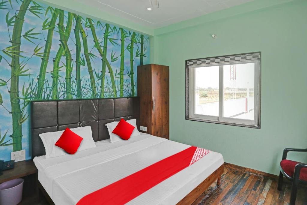 Un dormitorio con una cama con almohadas rojas y una ventana en OYO Flagship MH Inn en Varanasi