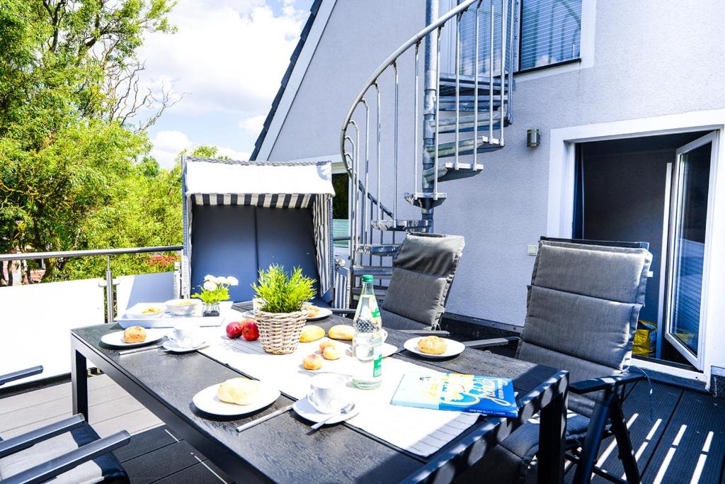 - une table sur un balcon avec de la nourriture dans l'établissement Haus Auszeit Meeresbrise, à Grömitz