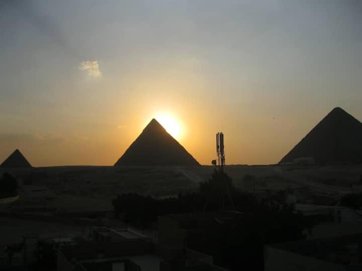 een zonsondergang boven de piramides in de woestijn bij sunwing pyramids view in Al Mahallah Al Kubra