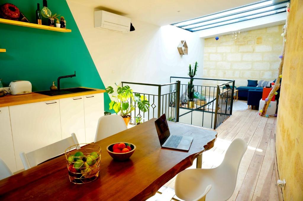 a kitchen with a wooden table with a laptop on it at Lovely townhouse Bordeaux in Bordeaux