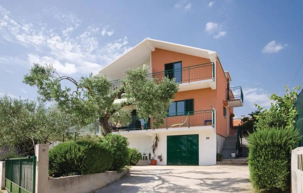 uma casa com uma garagem verde em frente em Apartments with a swimming pool Kastel Stafilic, Kastela - 22569 em Kaštel Novi