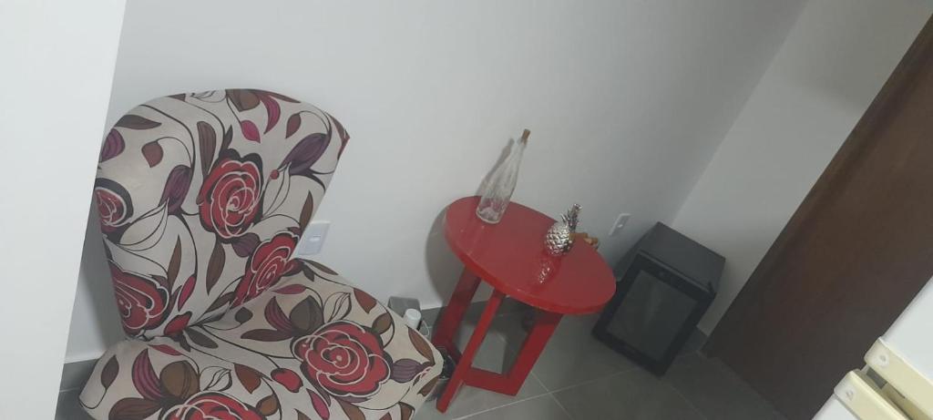 a living room with a chair and a red stool at APT PEDRA DO PONTAL Recreio in Rio de Janeiro
