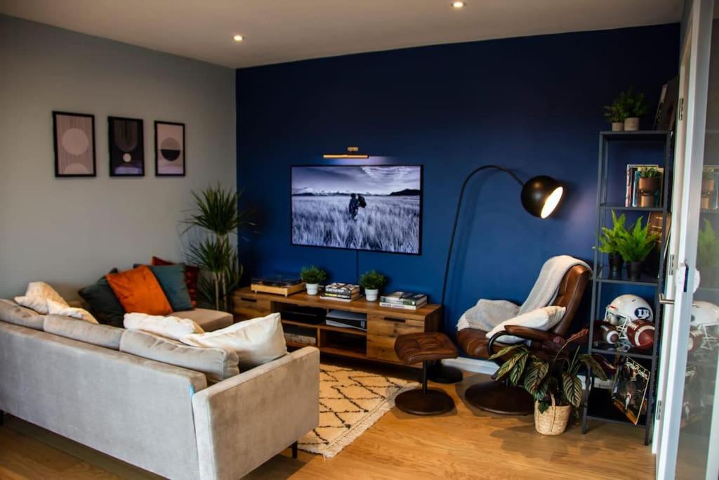 salon z kanapą i niebieską ścianą w obiekcie Cozy Urban Retreat in London w Londynie