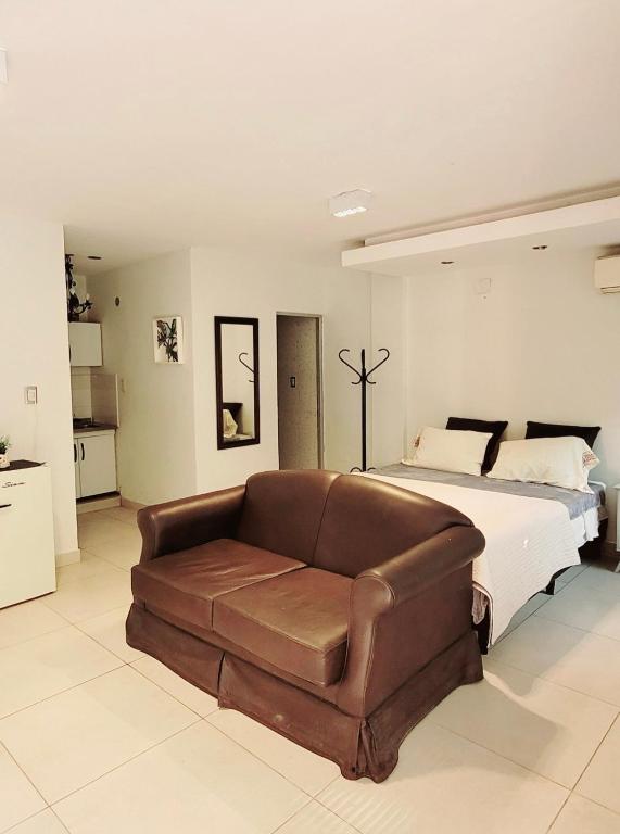 a bedroom with a bed and a leather couch at -AMBIENTE BOTIQUE- Tu lugar ideal- in Santiago del Estero