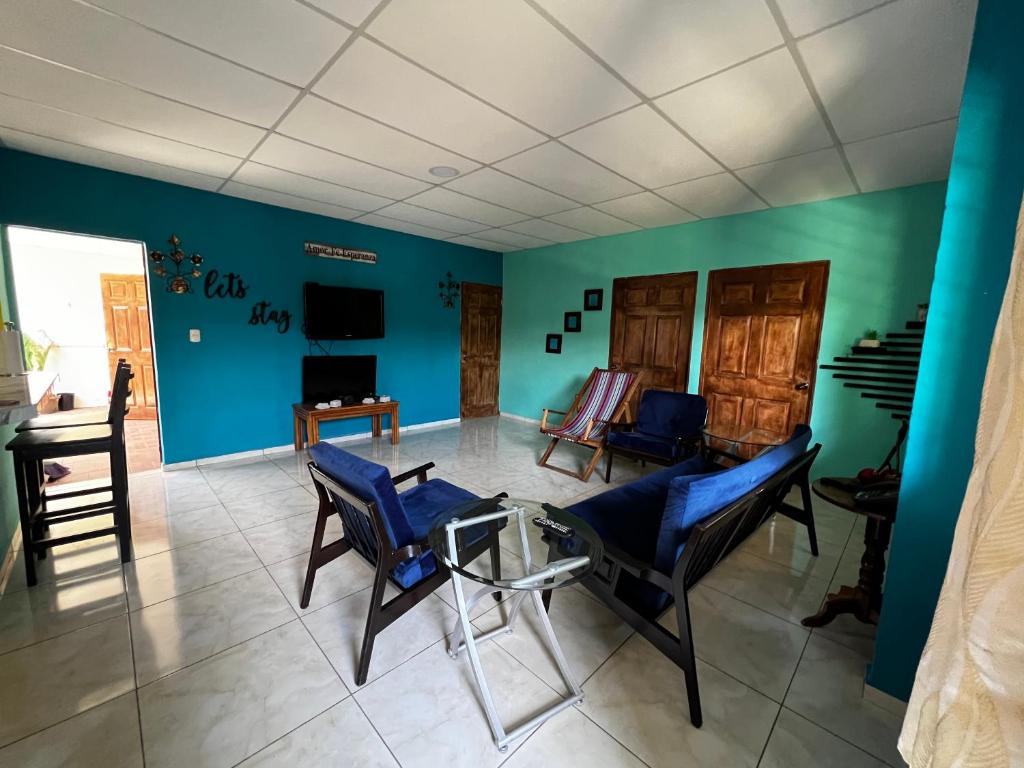 ein Wohnzimmer mit blauen Wänden und blauen Stühlen in der Unterkunft Casa de Emilia in Santa Ana