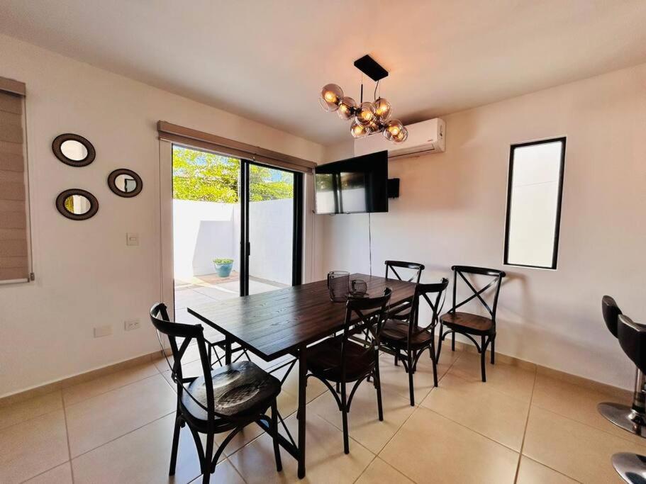 Un comedor con mesa y sillas de madera. en Hermosa casa a 2 min de la playa by PartnerHost, en La Florida