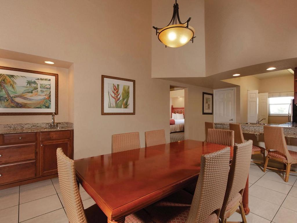 uma sala de jantar com uma mesa de madeira e cadeiras em Westgate town center resort em Orlando