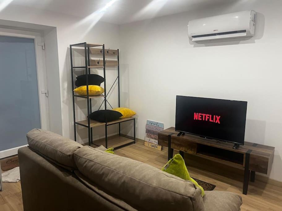 uma sala de estar com um sofá e uma televisão em Flat da Kaká em Maia