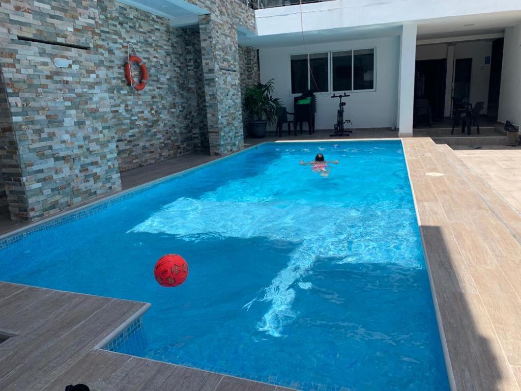 a person swimming in a pool with a ball in the water at Hotel Las Gaviotas in San Andrés