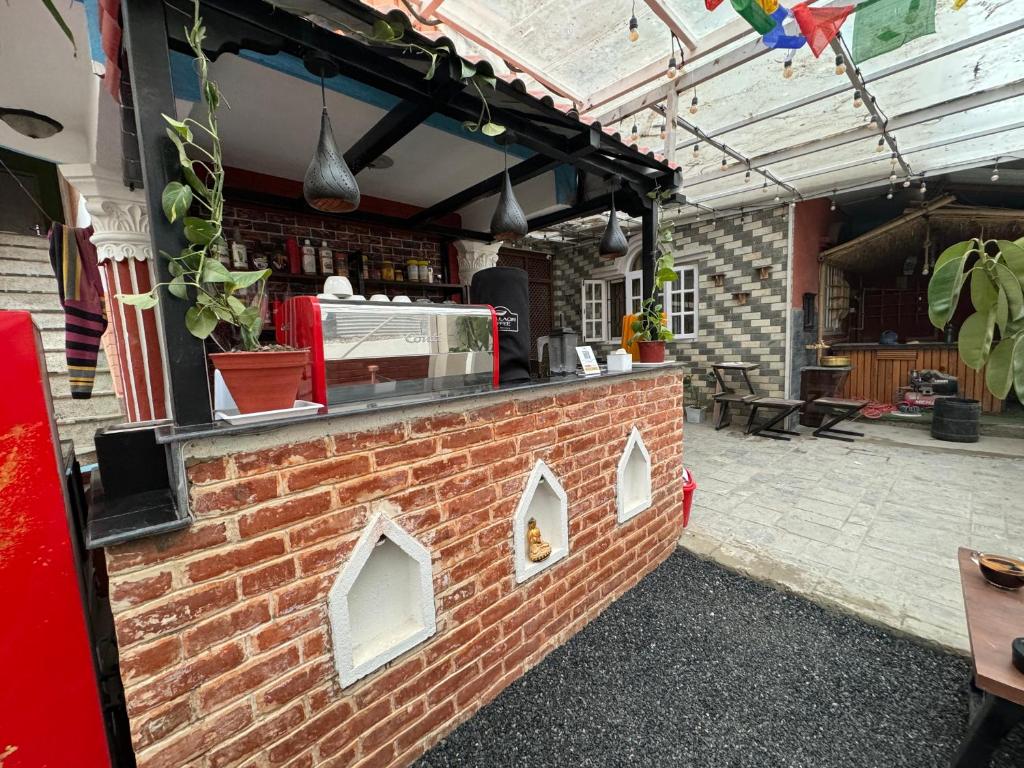 un bar de ladrillo con una parrilla en el patio en Hello KTM Hostel en Katmandú