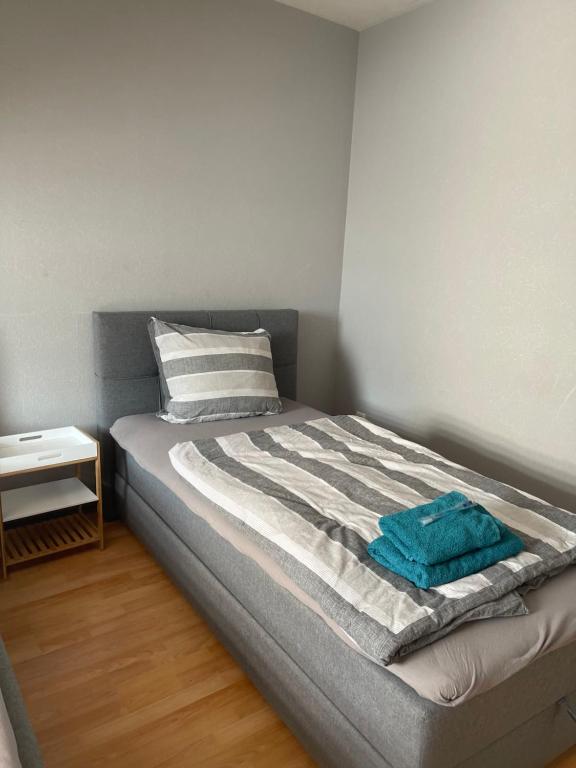 a bed with a blue towel on it in a room at Apartment groß 4 Zimmer in Essen