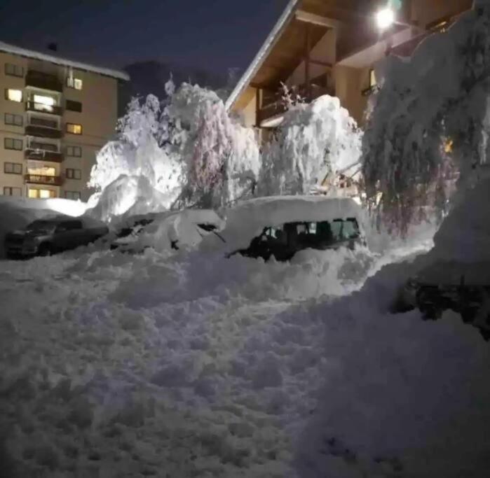 una pila de coches cubiertos de nieve aparcados en un estacionamiento en DEPARTAMENTO TERMAS DE CHILLAN, en Nevados de Chillán