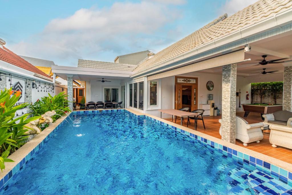 een villa met een zwembad en een huis bij Pattaya Private Villa - Pool,Sauna,Snooker,BBQ in Pattaya South