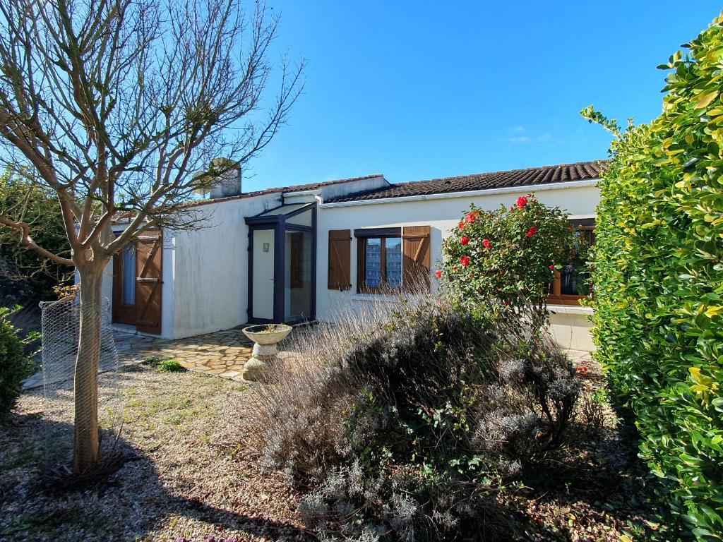 una casa blanca con un árbol en el patio en Maison L'Aiguillon-sur-Mer, 5 pièces, 6 personnes - FR-1-476-135, en LʼAiguillon-sur-Mer