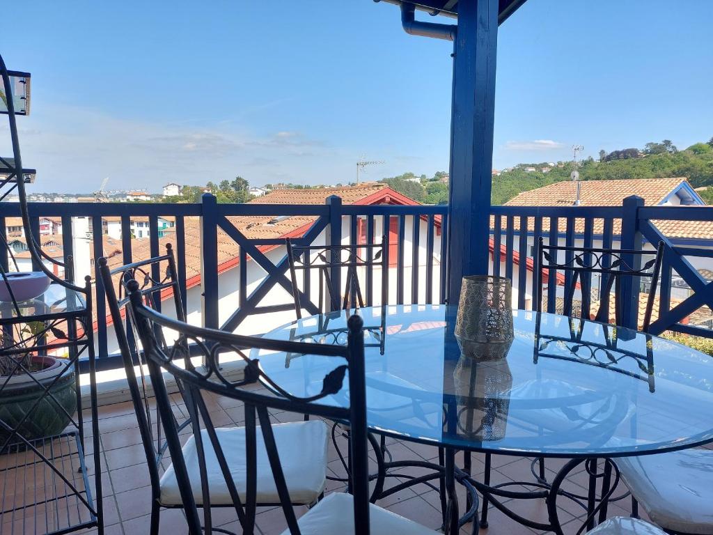 a glass table and chairs on a balcony at Appartement Urrugne, 3 pièces, 6 personnes - FR-1-239-772 in Urrugne