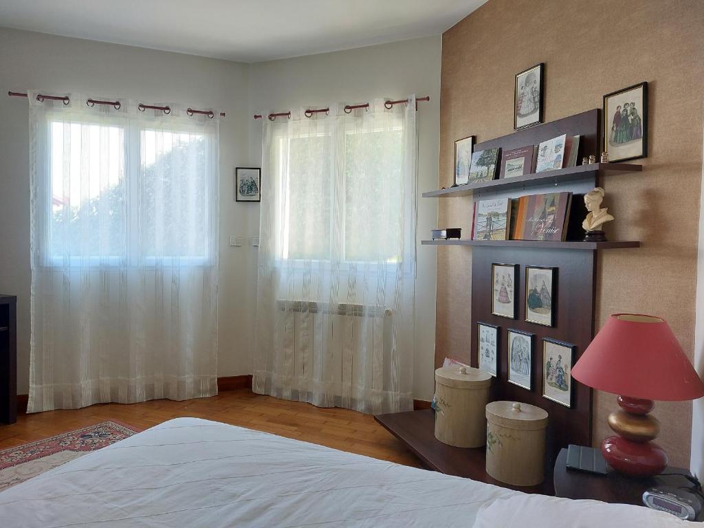 a bedroom with a bed and a window with white curtains at Appartement Urrugne, 3 pièces, 6 personnes - FR-1-239-772 in Urrugne