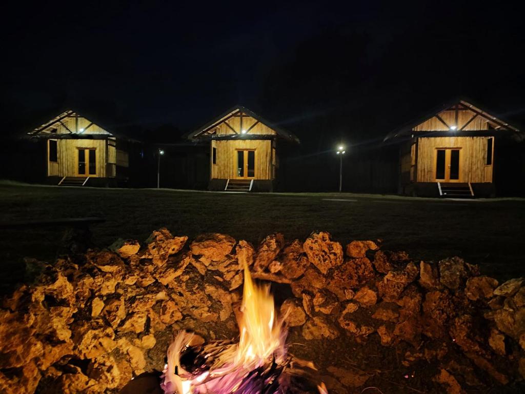 a fire pit in front of two buildings at night at Kahoy Cottages in Siquijor