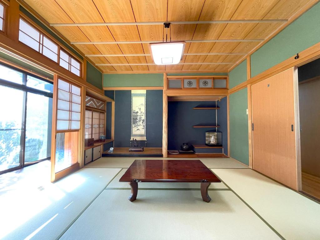 um quarto com uma mesa no meio em 道後の家 em Matsuyama
