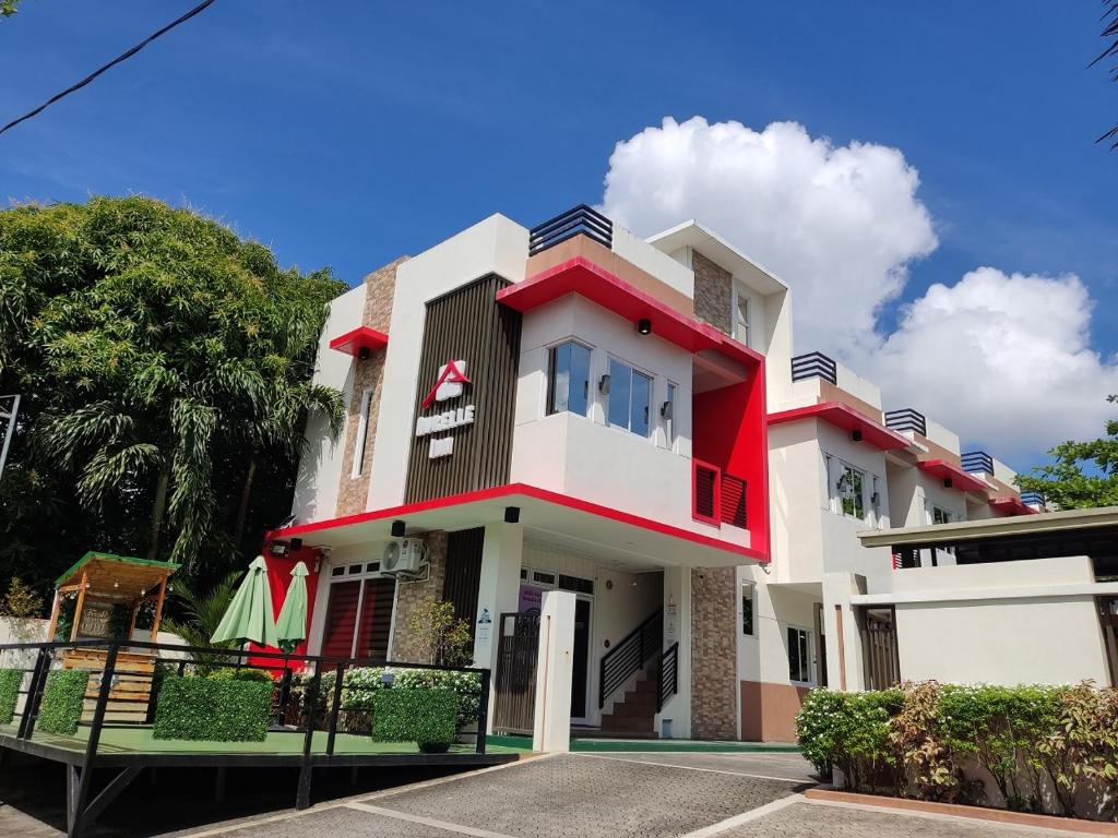 a white and red house with a blue sky at Aurelle Inn in Legazpi