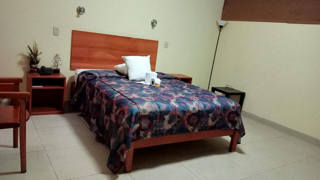 a bedroom with a bed with two teddy bears on it at Hotel Las Palmeras Iquitos in Iquitos