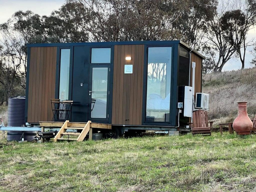 a tiny house sitting on top of a field at Willow Three Tiny House in Willow Tree