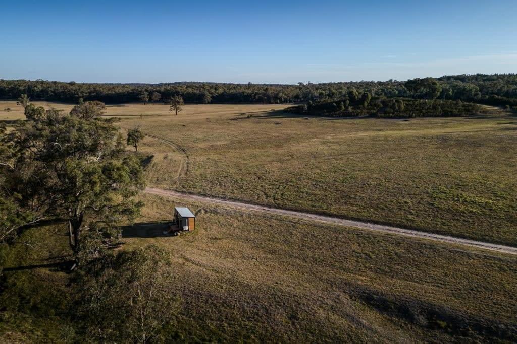 an aerial view of a field with a barn in the middle at Hermano Farm Stay 