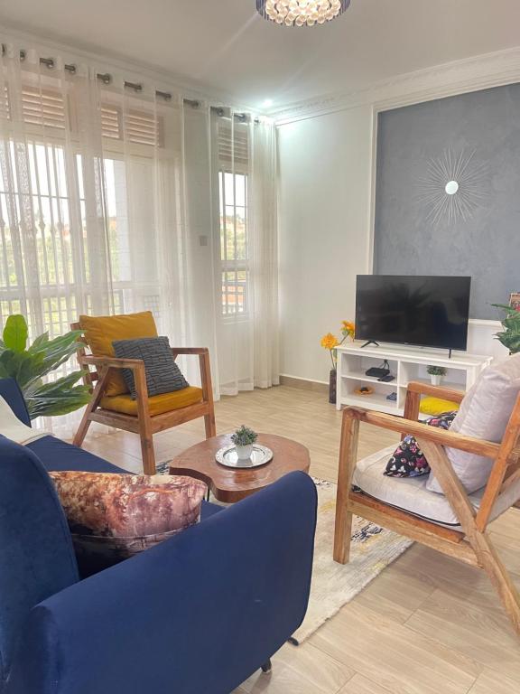 ein Wohnzimmer mit Möbeln und einem Flachbild-TV in der Unterkunft Serene Apartments in Bulindo