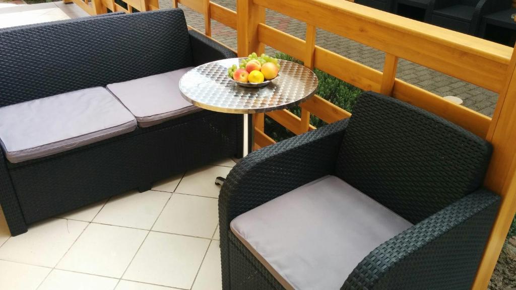 una mesa con un bol de fruta en el balcón en Bathory Apartments, en Hajdúszoboszló