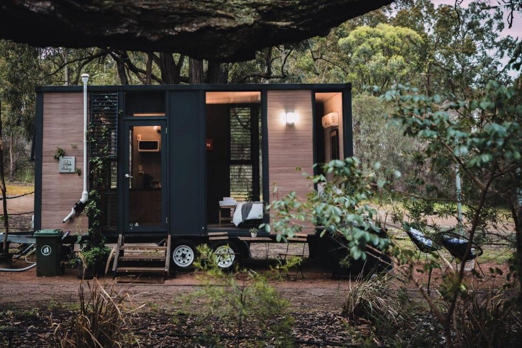 a tiny house sitting in the middle of a yard at Tiny House 888 in Pokolbin
