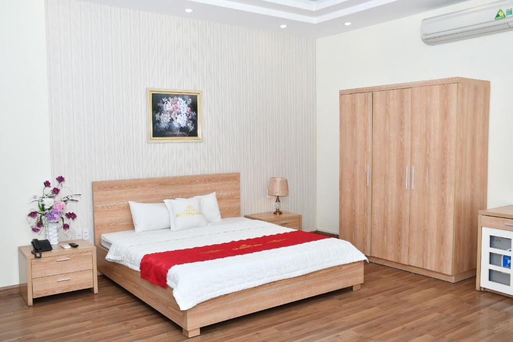 - une chambre avec un grand lit et une armoire en bois dans l'établissement Nhà Khách Hương Sen, à Hai Phong