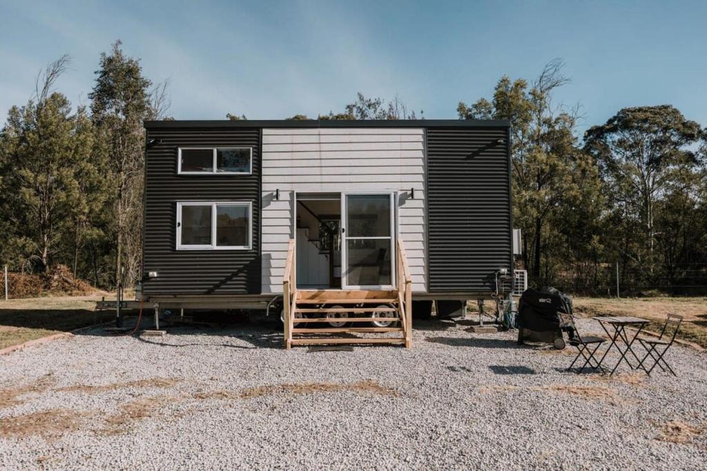 ein schwarzweißes, winziges Haus auf einem Schotterplatz in der Unterkunft The Big Wollombi Wanderer in Wollombi