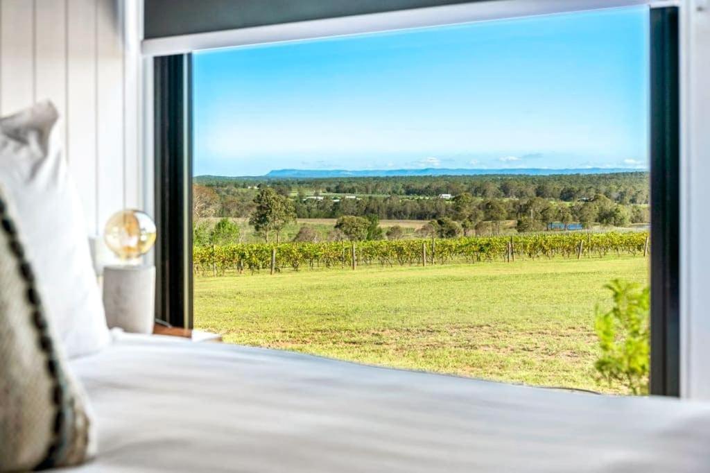 a bedroom with a large window with a view of a field at Valley Escape in Rothbury