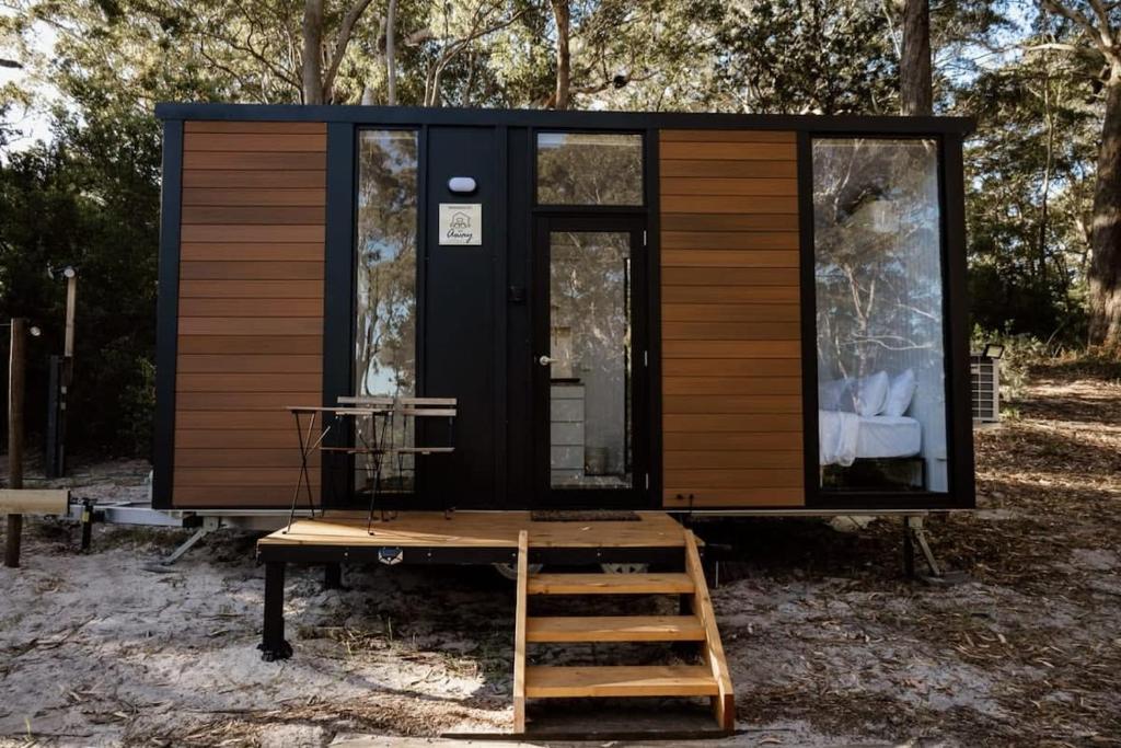 a tiny house on a trailer in the woods at Sunset Vine at Wonganella Estate 1 in Bobs Farm