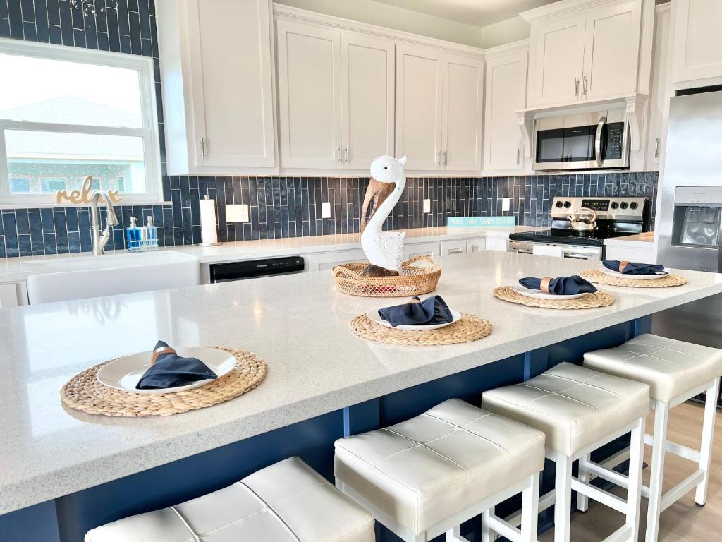Bolivar PeninsulaCalypso Cove-3bd 2b-Sleeps up to 12的白色的厨房,在柜台上设有天鹅雕像
