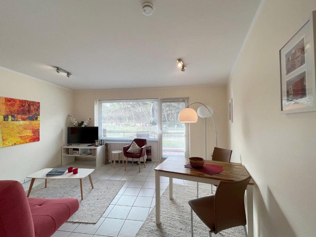 uma sala de estar com uma mesa e uma cadeira em Haus-Utlande-Whg-34 em Sankt Peter-Ording