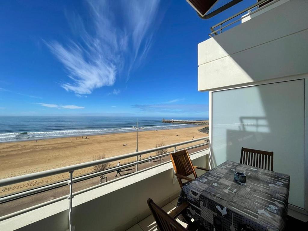 d'un balcon avec une table et une vue sur la plage. dans l'établissement Appartement T2 avec terrasse, climatisation et parking à Capbreton - FR-1-413-236, à Capbreton