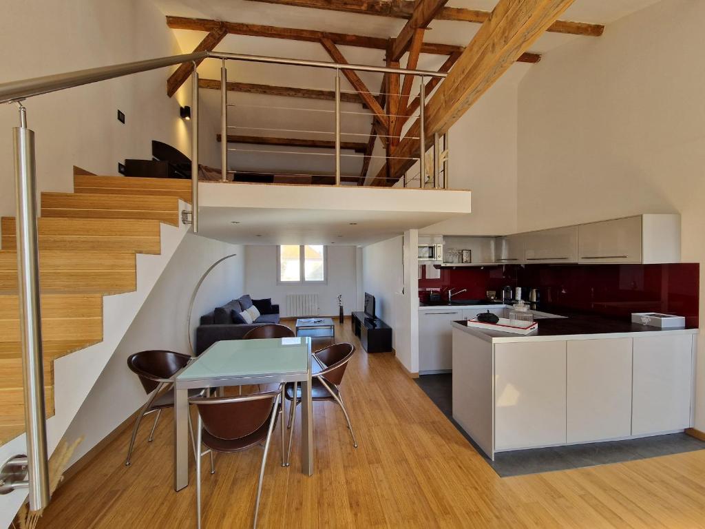 Il comprend une cuisine et un salon avec une table à manger et un escalier. dans l'établissement Loft 4 pers centre Châtelaillon-Plage, à deux pas de la mer et du Casino, Wi-Fi inclus - FR-1-706-26, à Châtelaillon-Plage