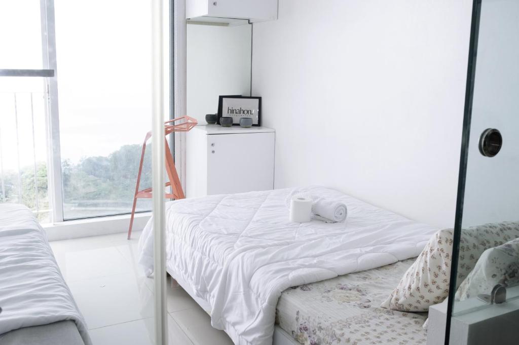 - une chambre blanche avec un lit et un miroir dans l'établissement Stunning Taal View Staycation in Tagaytay, à Tagaytay