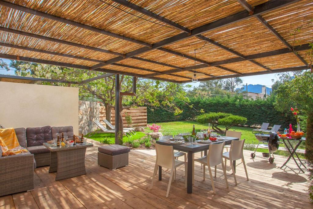 un patio esterno con pergolato in legno di Villa "Albizzia" avec terrasse et jardin 6 à 8 personnes a Calvi