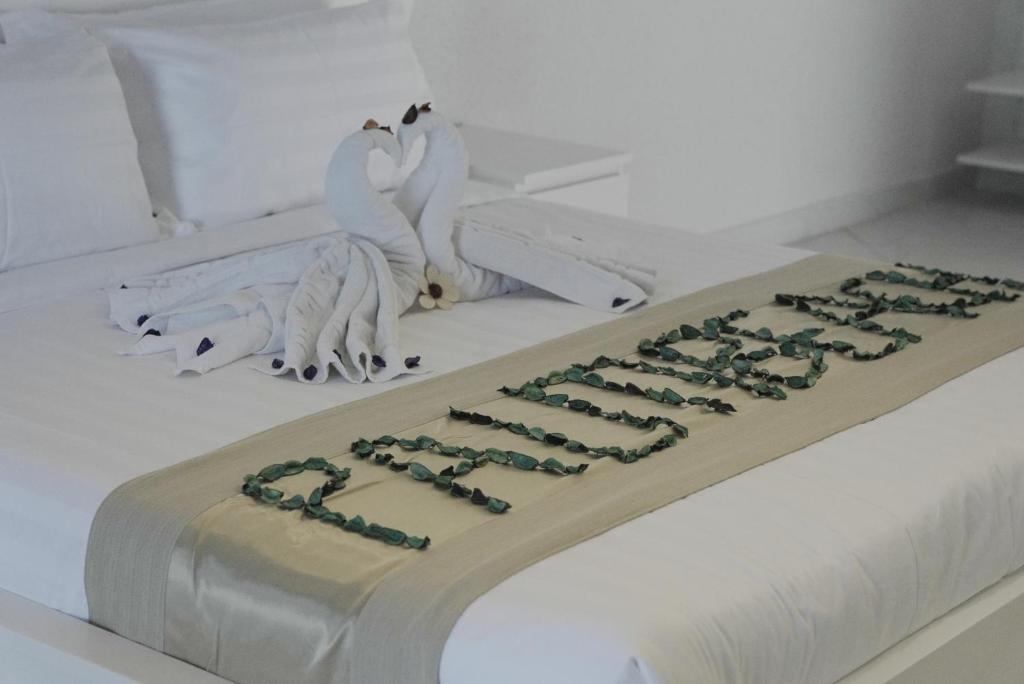 a cake with two white birds sitting on a bed at منتجع شاطئ النخيل in Half Moon Bay