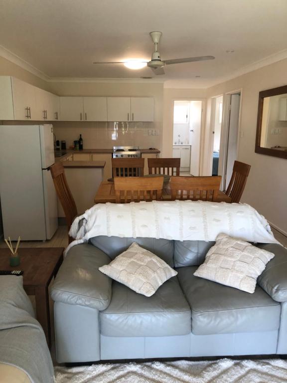 a living room with a couch and a kitchen at Zilzie Beach Apartment in Zilzie