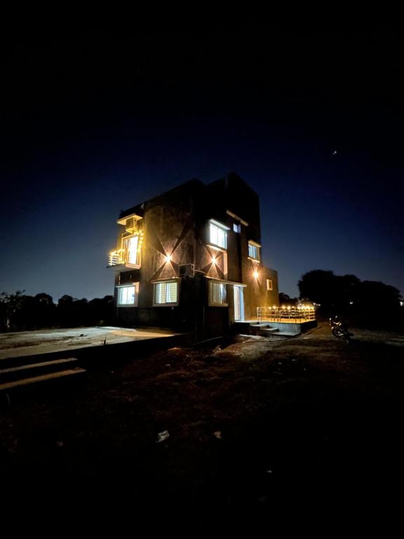 Una casa de noche con las luces encendidas en Vana FarmVille, en Mānglia