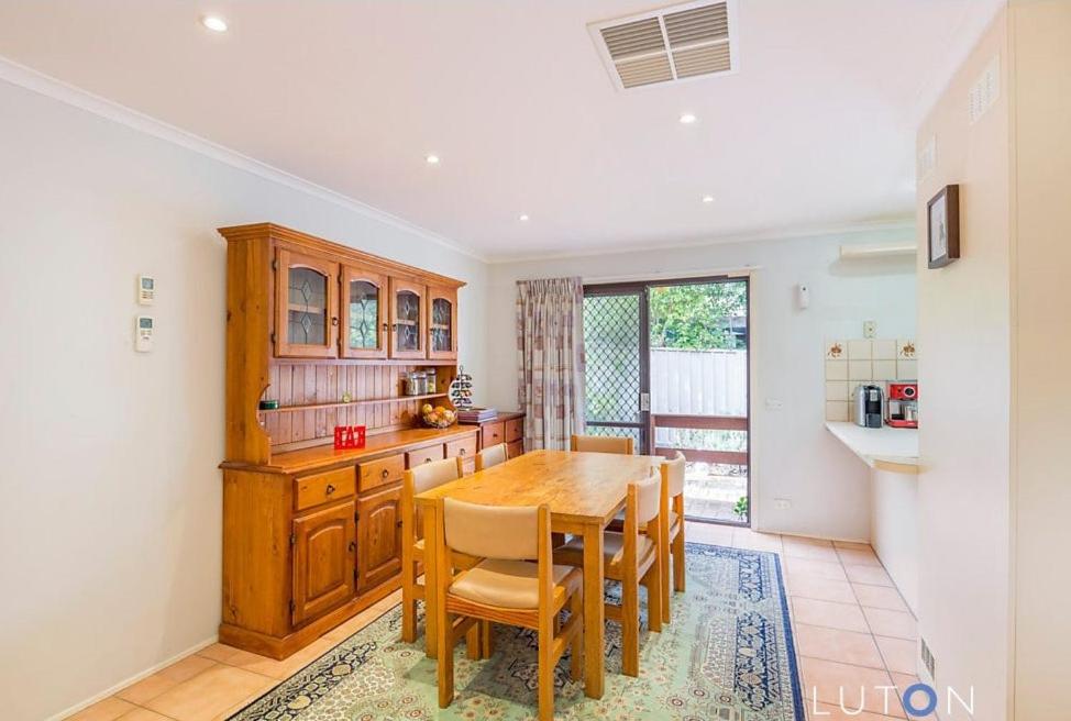 a kitchen with a wooden table and chairs at Convenience location with large living areas in Kambah