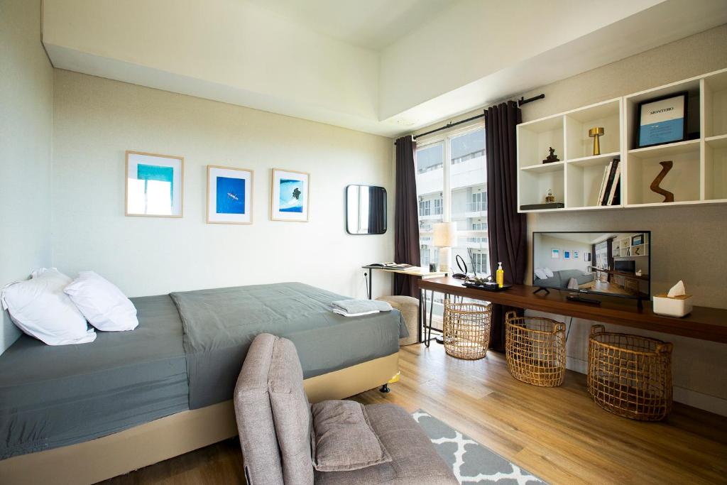 a bedroom with a bed and a desk and a window at Montero- Casa De Parco Panoramic View Apartment in Tangerang