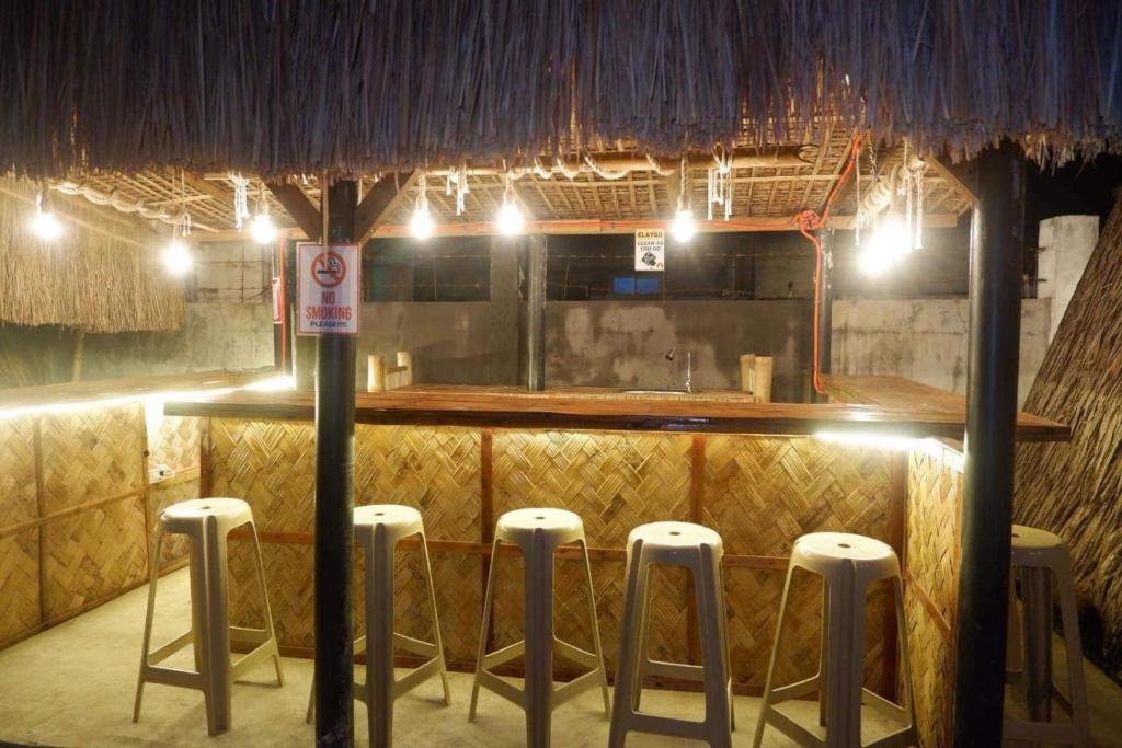 un bar con taburetes en una habitación con luces en Balay Inton near Masasa Beach Tingloy en Tingloy
