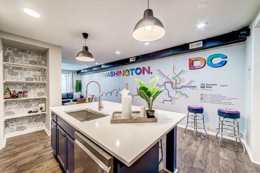 a kitchen with a sink and a counter with stools at TheWrightStays Art Haven at Fairlawn Gardens in Washington, D.C.