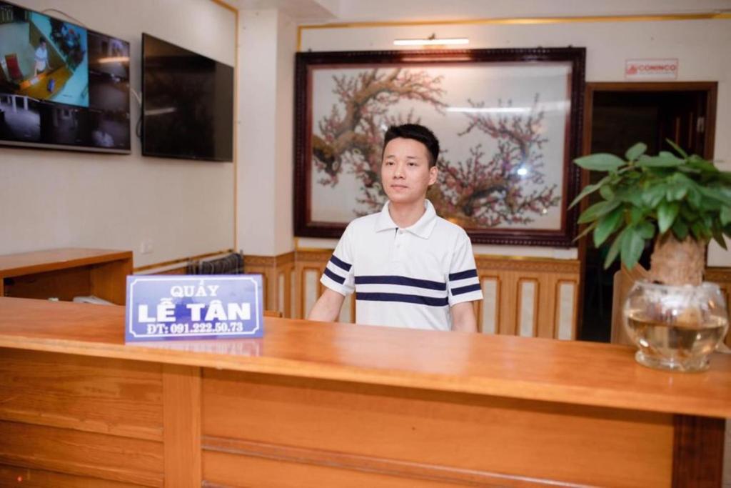 ヴィンにあるThảo Nguyên Hotelのサロンの窓口に立つ男