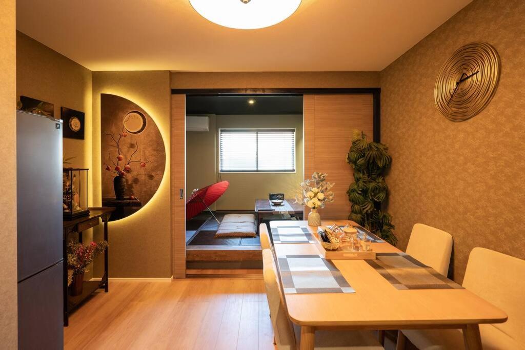une salle à manger avec une table et une cuisine avec une salle à manger dans l'établissement 錦・【金瑞軒】名古屋駅徒歩8分まるまる貸切, à Nagoya