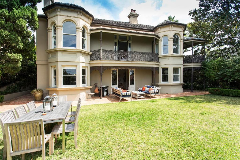 a large house with a table and chairs in the yard at Victorian Masterpiece in Sydney